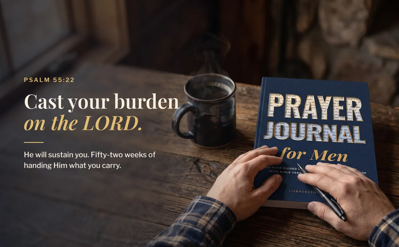 A man with his hand on Prayer Journal for Men at a wooden table, with Psalm 55:22, Cast your burden on the Lord